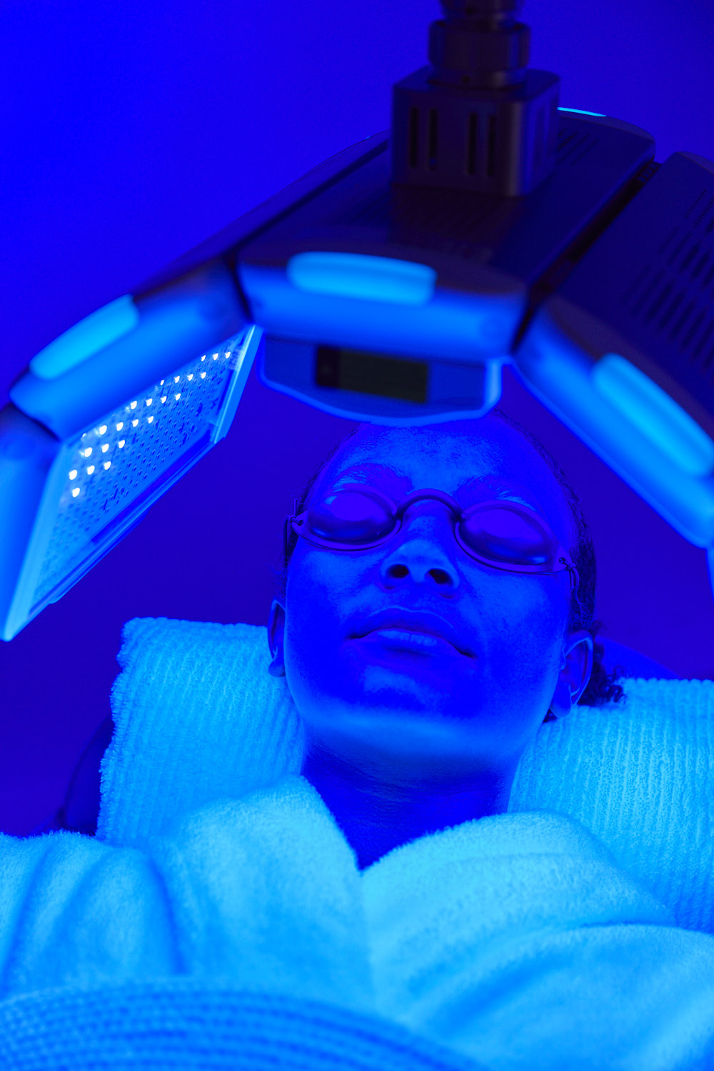 Close-up of blue LED light therapy being used to treat active acne and bacteria at Body Sculpting Clinics Sydney
