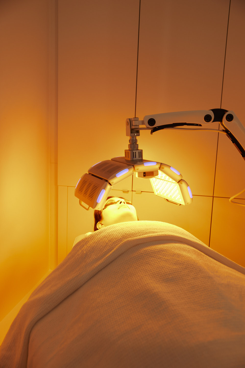 Client receiving a soothing yellow LED light therapy facial treatment to calm redness and support skin tone at Body Sculpting Clinics Sydney.